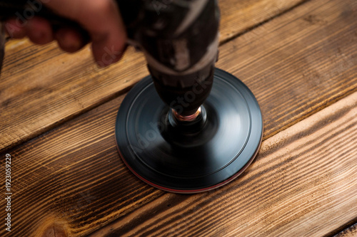 Wood surface polishing with electric tool close up