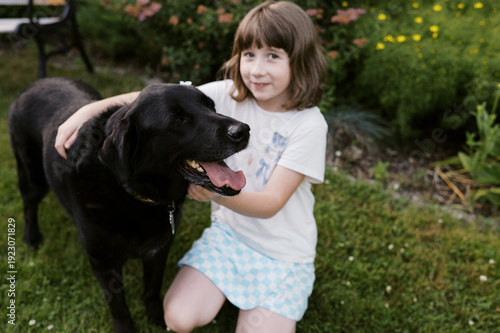 happy dog with little girl in garden at home