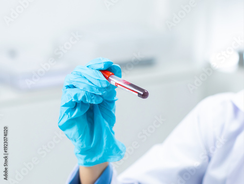 Photos Gloved hand holding blood vial for medical testing in modern lab