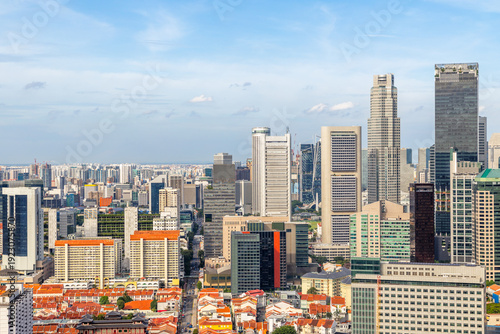 Panoramic skyline of Singapore central business district with dense modern skyscrapers and traditional red residential rooftops