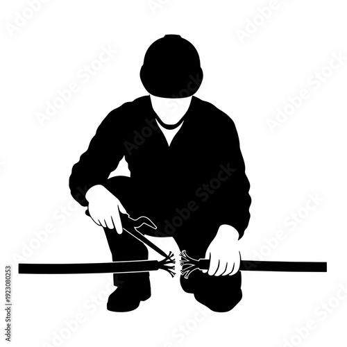 A silhouette of a worker in a hard hat crouching and repairing a cable with tools.