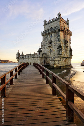 Photos Iconic Belém Tower (Torre de Belém) at golden sunset, historic Manueline fortress on the Tagus River shore with wooden walkway, UNESCO World Heritage Site in Lisbon, Portugal, scenic evening light