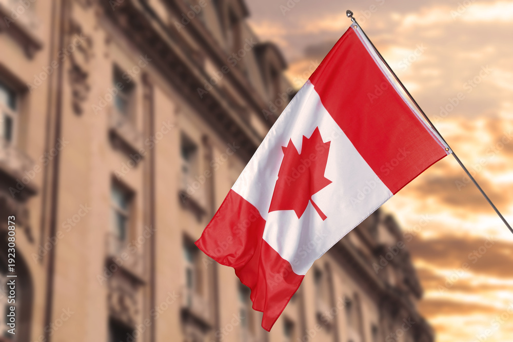 Obraz premium Flag of Canada waving against building outdoors. National symbol
