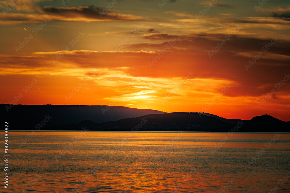 Obraz premium Abendstimmung am Bodensee mit Blick auf das Wasser und untergehender Sonne am Horizont