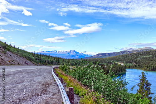 Winding highway and snow covered mountains by the Emerald Lake, YT, Canada