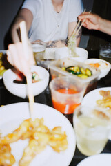 Anonymous people eating Chinese food using chopsticks 