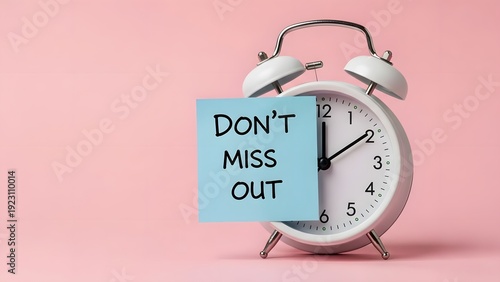 Vintage alarm clock with don't miss out note on pink background