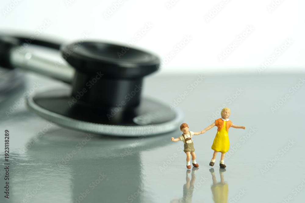Obraz premium Miniature people toy figure photography. Fun medical checkup concept. Kids with stethoscope