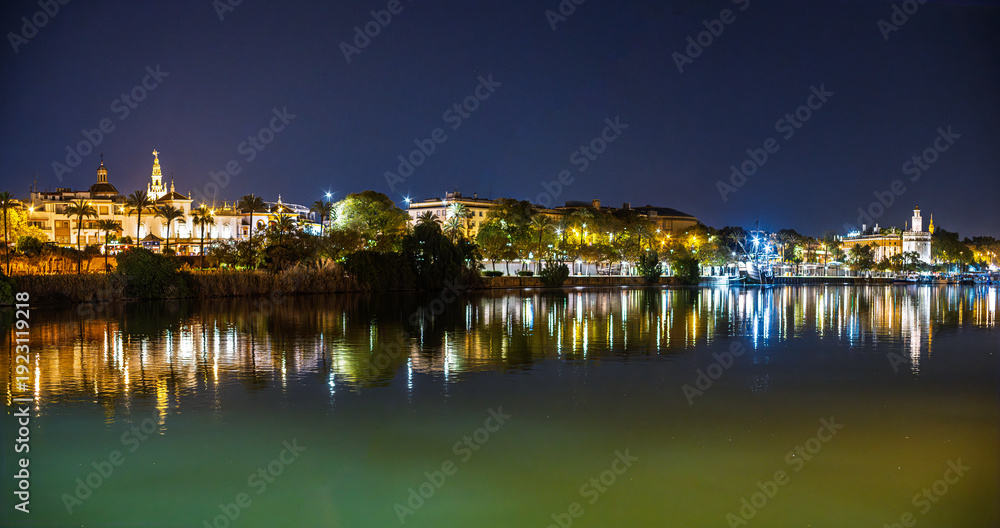 Obraz premium Seville Night Panorama Reflected Guadalquivir, Giralda, Torre del Oro