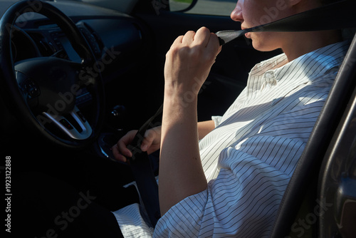 Woman fastening seatbelt in a car