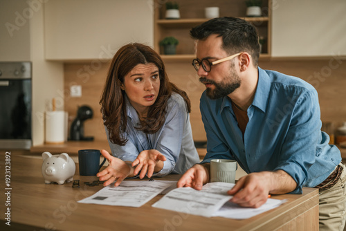 Fotografie Couple having financial discussion in kitchen over bills