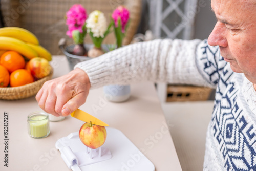 Senior man using adaptive non-slip cutting board for disabled with apple holder, inclusive kitchen aid people one hand mobility, rehabilitation process, stroke survivors, arthritis patients home care,