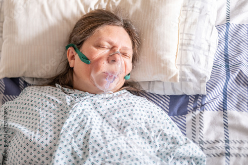Schilderij op canvas female patient in bed with oxygen mask, Human-centered health support, respirato