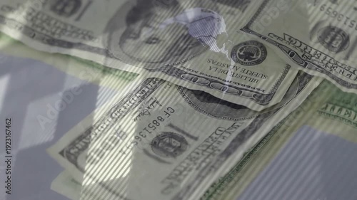 US $100 bill entering frame, camera moving closer, bills stacking and settling for glossy demo