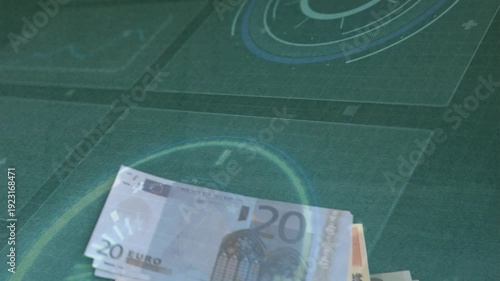 I am adding and fanning 20-euro notes after edge appears, forming stacked pile on green mat