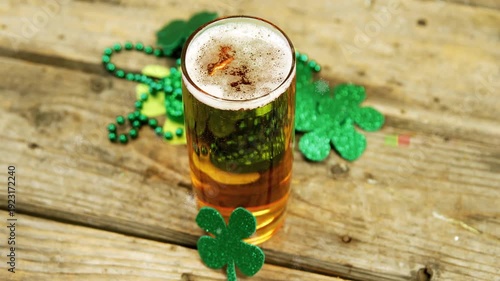 Camera shifting angle and zooming to show shamrocks, pint glass showing foam while highlights glint