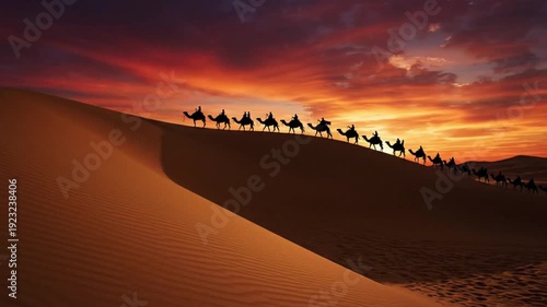 Silhouetted caravan of camels traversing the vast arid sand dune crest under a dramatically colorful and fiery desert sunset sky horizon