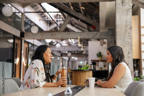 Two colleagues discussing ideas in a modern industrial-styled office