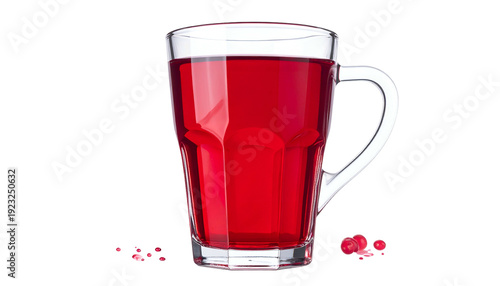 A tall, clear glass mug is filled with a vibrant red beverage. Scattered berries lie beneath the glass against a black background