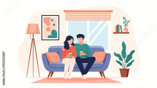 Happy young couple sitting on a blue sofa drinking coffee or tea in a cozy modern living room with a bright window and plants.