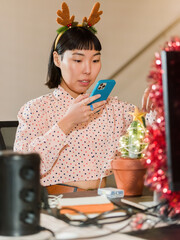 Woman With Antlers Photographing Christmas Decoration on Cactus