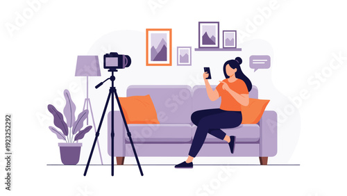 Young female influencer sitting on a couch in her living room records a video for her followers using a smartphone and a professional camera.