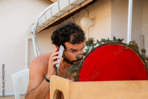Young man clipping his hair with an electric razor