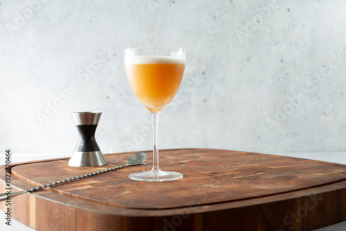 A view of a whiskey sour in a Nick and Nora glass.