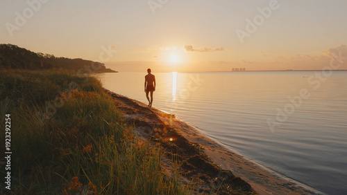 Man Walking on Beach at Sunrise