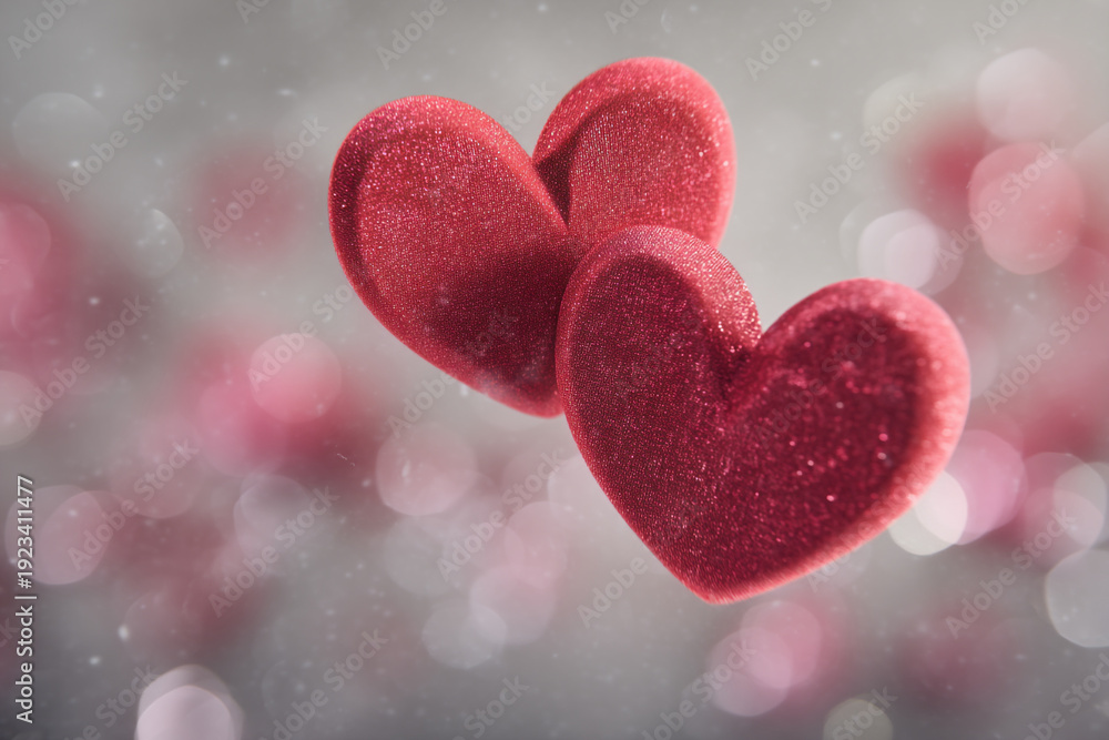 Obraz premium Two red hearts are floating in the air with a bokeh background