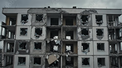 Destroyed apartment building with gaping holes where windows once were, showcasing urban decay and devastation