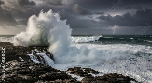 A powerful wave crashes against the rocky shoreline under a stormy sky