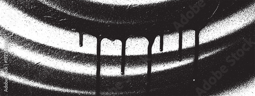 Abstract black and white spray paint drips on a textured surface.