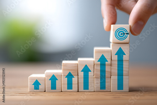 Hand is placing a block on top of a stack of blocks with a blue arrow pointing