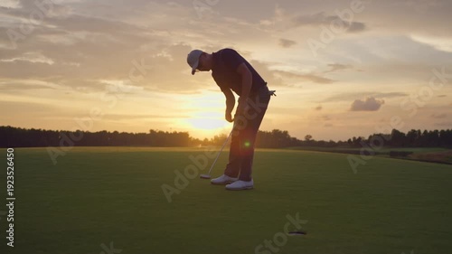 Professional young male golfer swings his club on scenic golf course. 