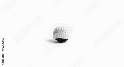A knitted sphere with a white cap over a dark blue base