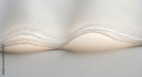 Close-up macro of rippled white paper layers, softly backlit with warm light, creating a gentle abstract textured background.