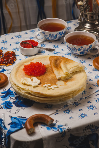 Pancakes on the table next to the samovar and caviar