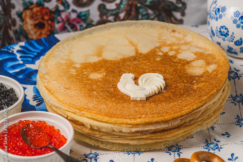 Pancakes on the table next to the samovar and caviar