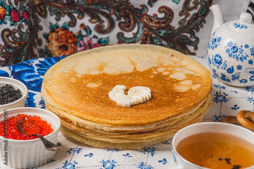 Pancakes on the table next to the samovar and caviar