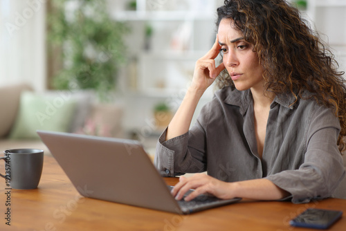 Bilde på lerret Worried adult woman at home checking bad news on laptop