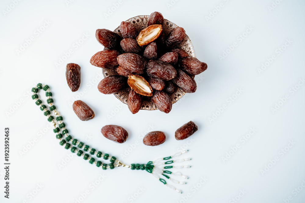 Fototapeta premium Simple clean flat lay for Ramadan with dates and green prayer beads