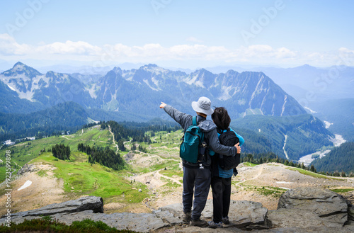 Man pointing to the distant view. Couple enjoying the view from Skyline Loop Trail. Mt Rainier National Park. Washington State.