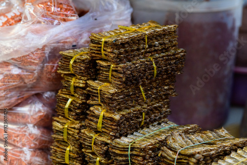 Принти на полотні Neatly arranged bundles of dried fish tied with yellow plastic bands are stacked on a market counter in Kampot, Cambodia