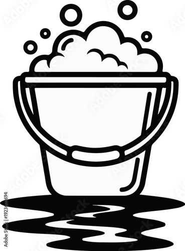 Black and white illustration of a bucket filled with suds and bubbles, with a puddle