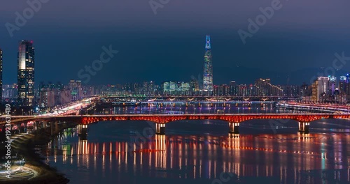 Stunning night aerial hyperlapse panning along seongsu bridge over han river with glowing Lotte tower