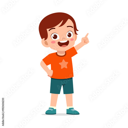 Happy Asian young boy in orange t-shirt and blue shorts pointing up cheerfully smiling