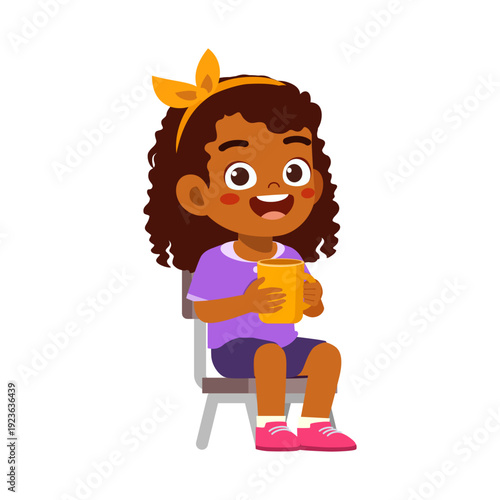 Happy African American girl sitting on chair holding yellow mug smiling cheerfully looking forward with a bow headband
