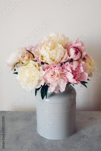 Beautiful bouquet of fresh colorful peonies in full bloom in vase. Floral spring still life.