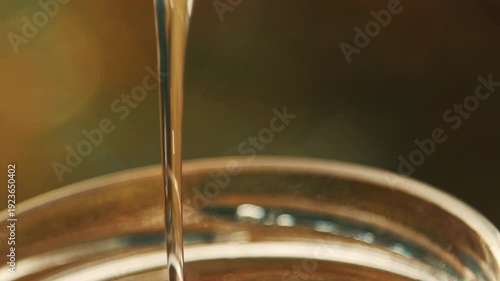 Wallpaper Mural Close-up detailed view of a beekeeper's hand stirring golden acacia honey in a glass jar at the apiary, showcasing the texture Torontodigital.ca